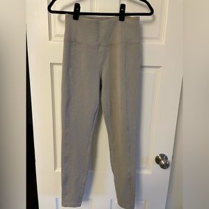 Light grey athleta leggings with back zipper pockets and waistband pockets